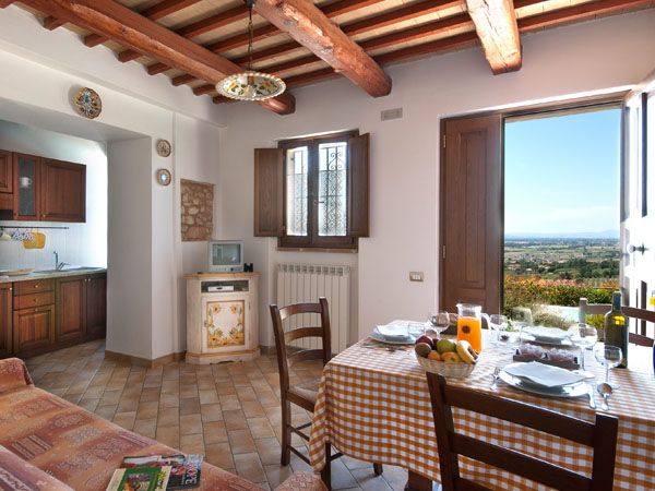 A cozy living room with a view of the Umbrian countryside. The spaces are bright and promote relaxation.