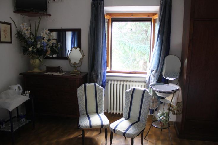 Sleek interior with two chairs, a cabinet, and a window allowing natural light to enter.