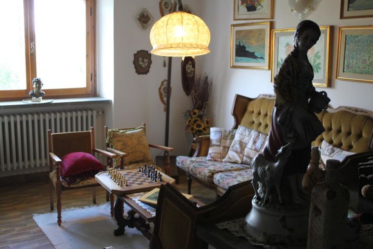 A cozy room in an Umbrian building, furnished with simple elements and a chess table.