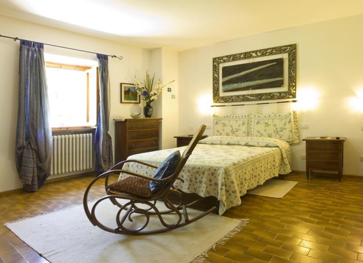 A simple agriturismo room with functional furnishings and a view of the surrounding nature.