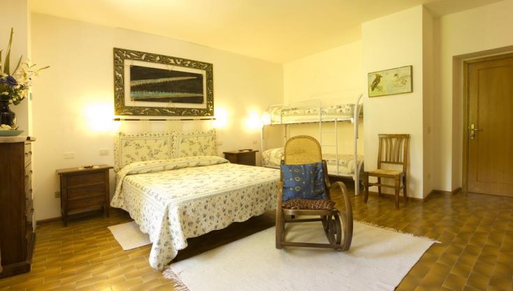 A cozy agritourism room featuring a double bed and bunk beds for a relaxing stay.