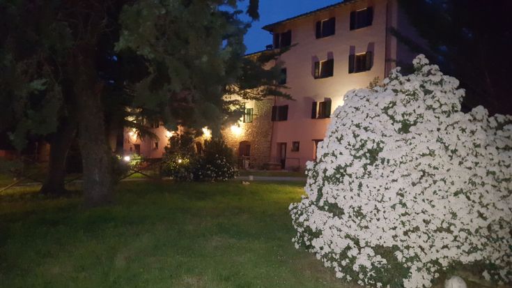 Spaziosa casa padronale immersa in un giardino ben curato, ideale per un momento di relax al tramonto.