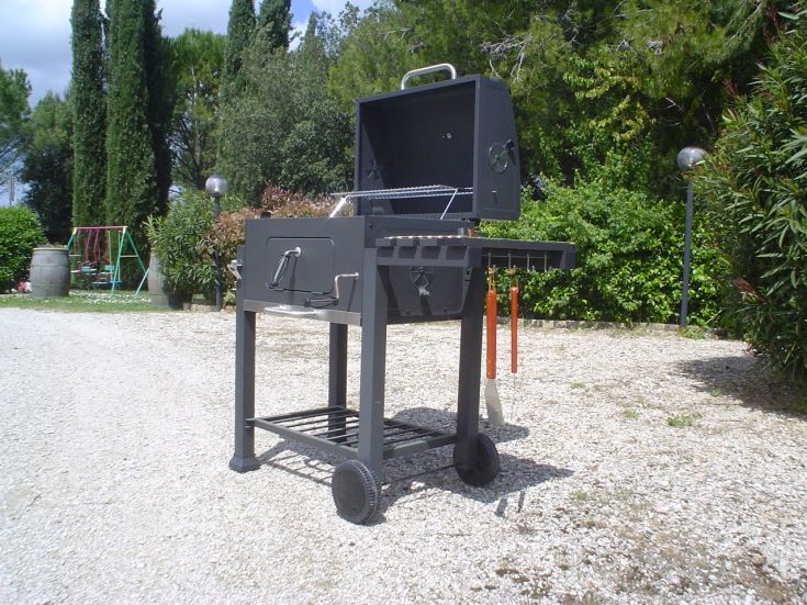 Un barbecue simple pour griller, entouré de verdure dans une ferme en Ombrie.