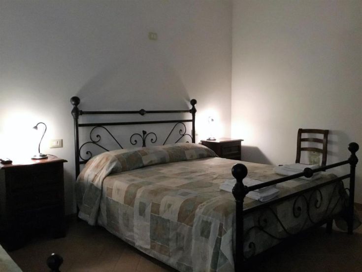 Chambre paisible avec un lit double, un éclairage doux et un mobilier simple pour un repos serein.