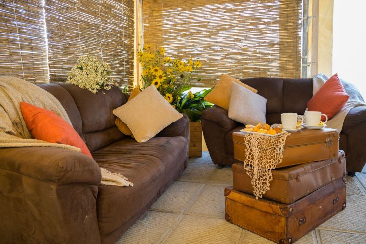 Un soggiorno semplice con divani e cuscini, arricchito da un tavolo. L'atmosfera è tranquilla e accogliente.