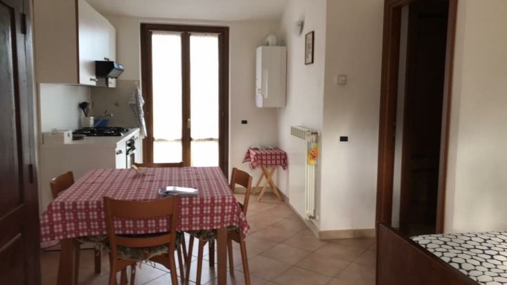 Gemütliche und funktionale Küche mit Tisch und Stühlen, ideal für gesellige Momente.