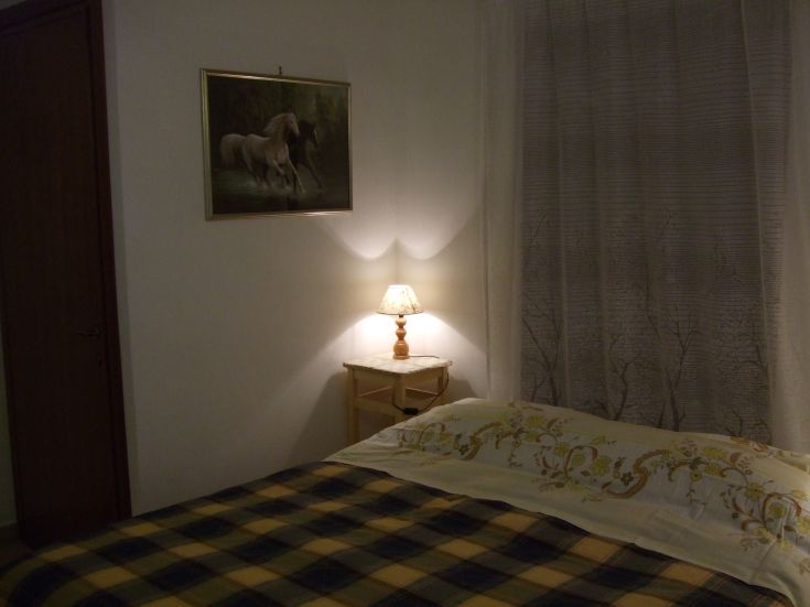 Einfaches und ordentliches Zimmer mit Einzelbetten und sanfter Beleuchtung, perfekt für Ruhezeiten.