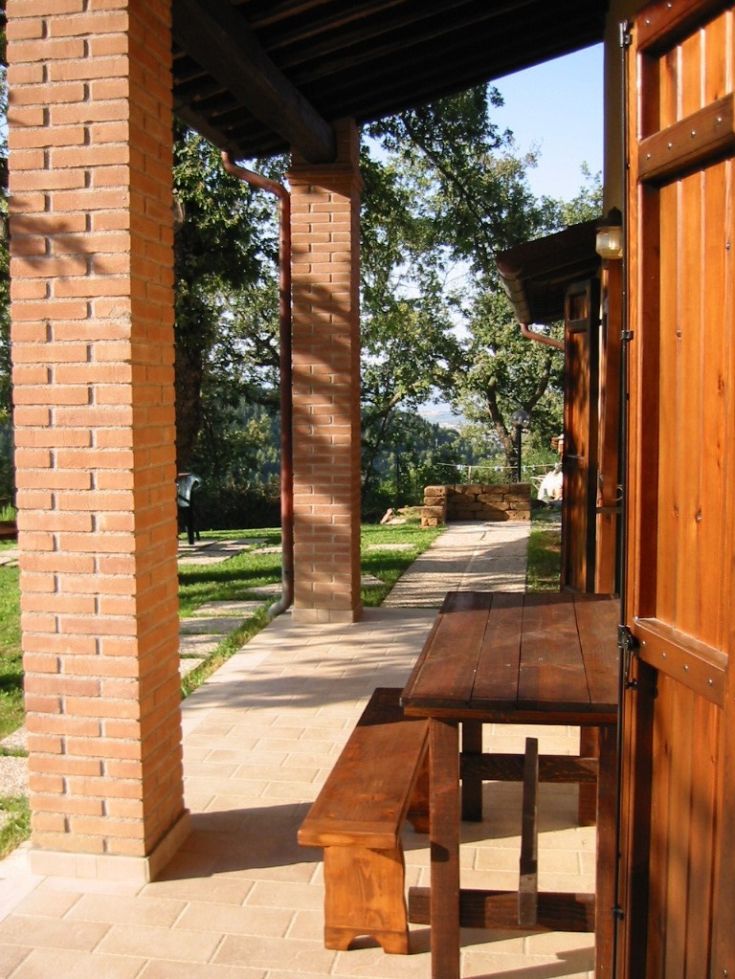 Ein einfacher Außenbereich mit einem Holztisch, umgeben von Pflanzen und Grün.