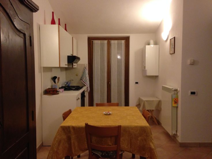 Einfache und gemütliche Küche, eingerichtet mit einem Tisch und wesentlichen Elementen für eine ruhige Atmosphäre.