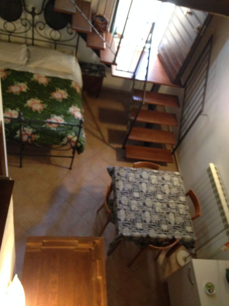 Gemütliches Interieur mit einem Bett, einer Wendeltreppe und einem Tisch. Idealer Raum für eine kurze Pause.