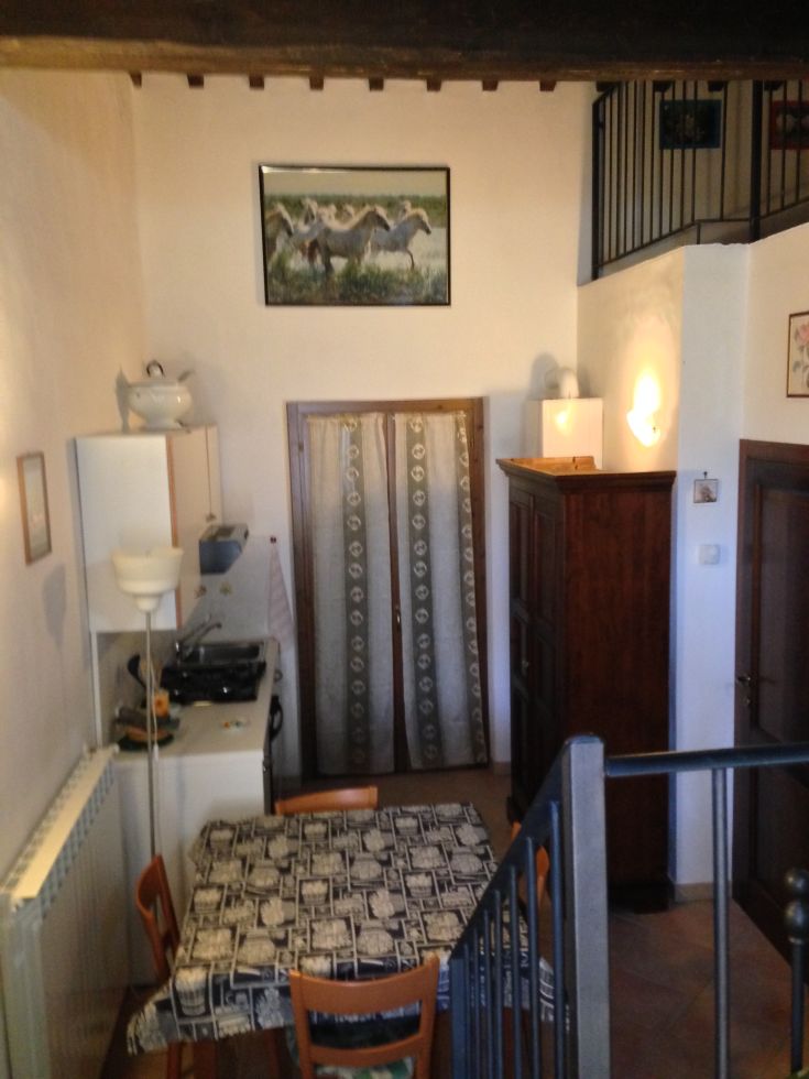 Einfache Küche mit Tisch und Kochnische, ideal für informelle Mahlzeiten.