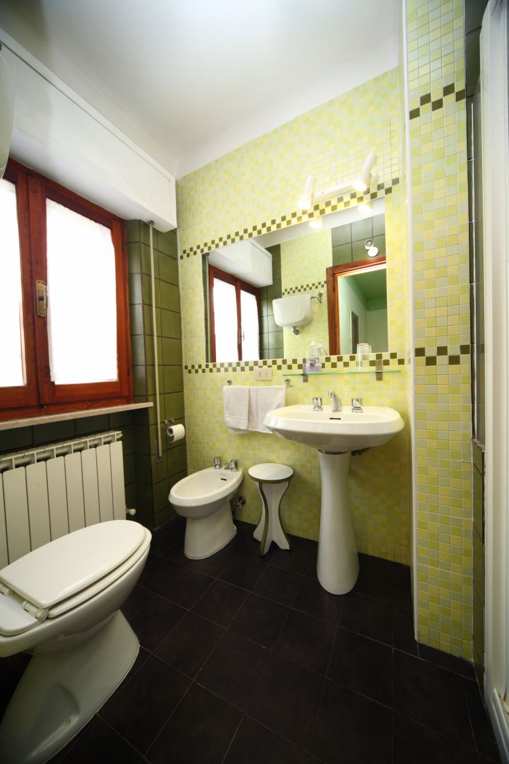 Geräumiges Bad mit lebhaften Keramikfliesen, ausgestattet mit Toilette und Bidet.
