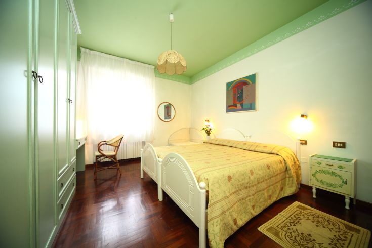 Helle und einladende Zimmer mit grünen Akzenten und einfachen Möbeln. Perfekt für einen angenehmen Aufenthalt.