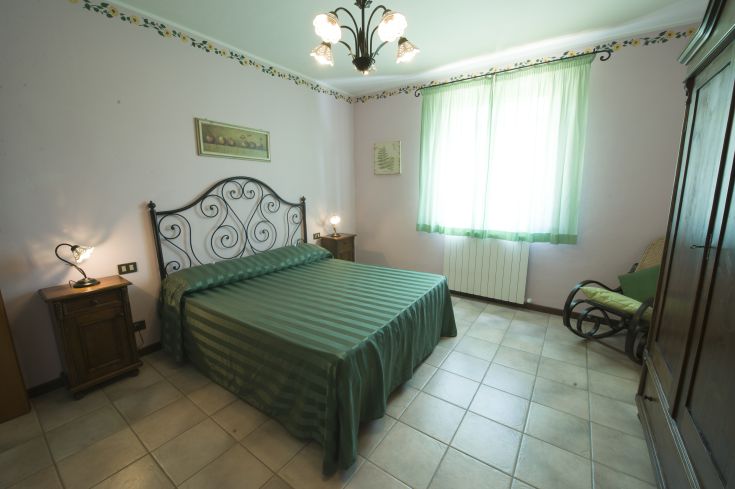 Camera con letto matrimoniale e arredamento essenziale, situata in un ambiente tranquillo.