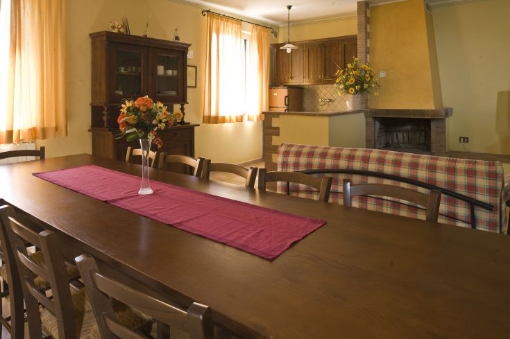 Un ambiente confortevole con un tavolo in legno e decorazioni floreali, ideale per momenti di relax.