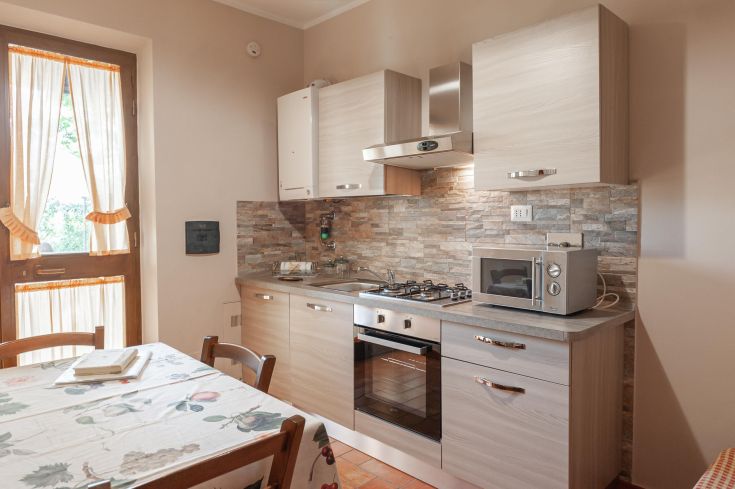Cucina semplice e funzionale, dotata di elettrodomestici moderni e mobili pratici.