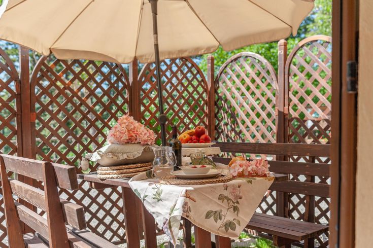 Un'area esterna semplice e accogliente, con un tavolo decorato, perfetta per momenti di tranquillità immersi nella natura.