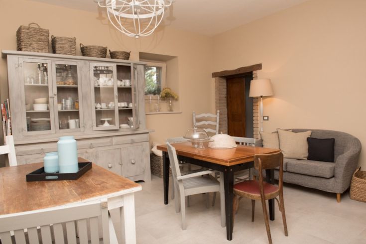 Interno di un edificio con un tavolo di legno, arredi semplici e dettagli ben curati.