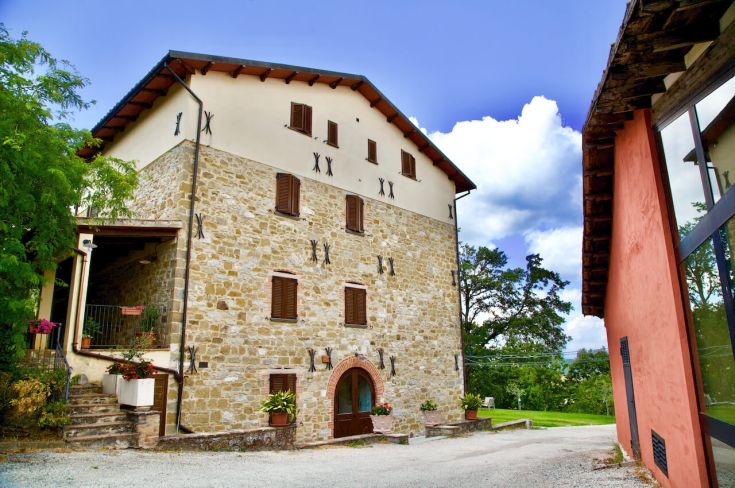 Una struttura in pietra immersa in un ambiente naturale, con caratteristiche architettoniche tipiche dell'Umbria.