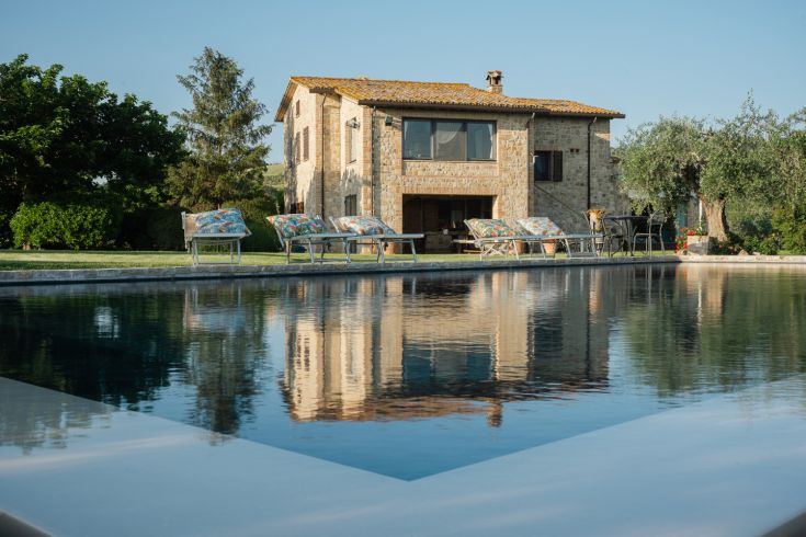 A building surrounded by lush greenery, featuring an outdoor pool for relaxation.
