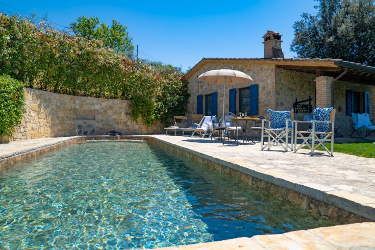 A farmhouse with a pool surrounded by greenery, ideal for relaxation and tranquility.