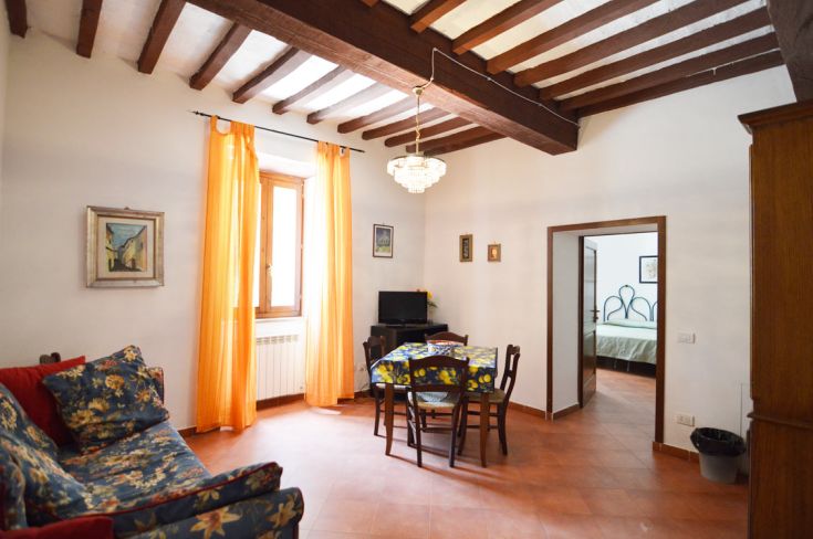 Cozy living room with a sofa and table, decorated in warm and bright tones.