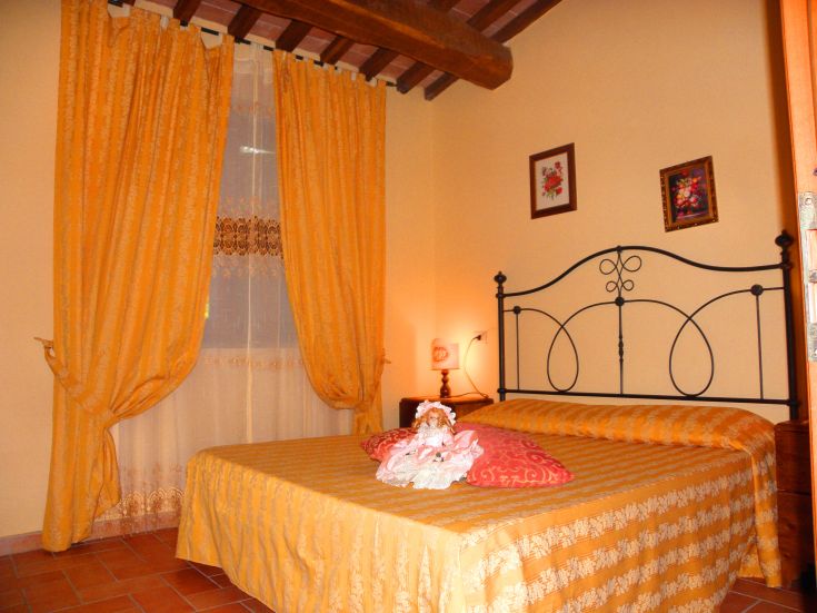 Simple room with yellow curtains and decorative elements, perfect for a peaceful stay.