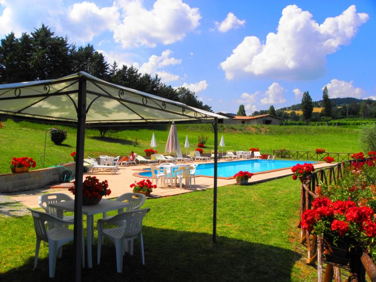 A farmhouse surrounded by nature, featuring a pool and stunning views of the Umbrian landscape.
