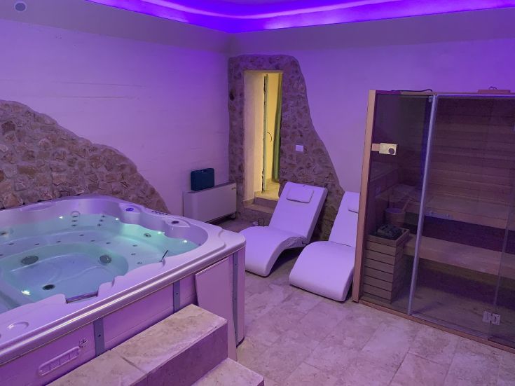 Interior of a wellness center featuring a jacuzzi and sauna, enhanced by warm and cozy lighting.