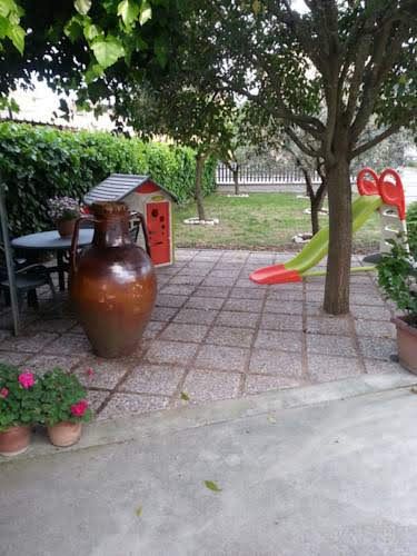 Une zone extérieure avec des jeux et des plantes dans un environnement calme et accueillant.