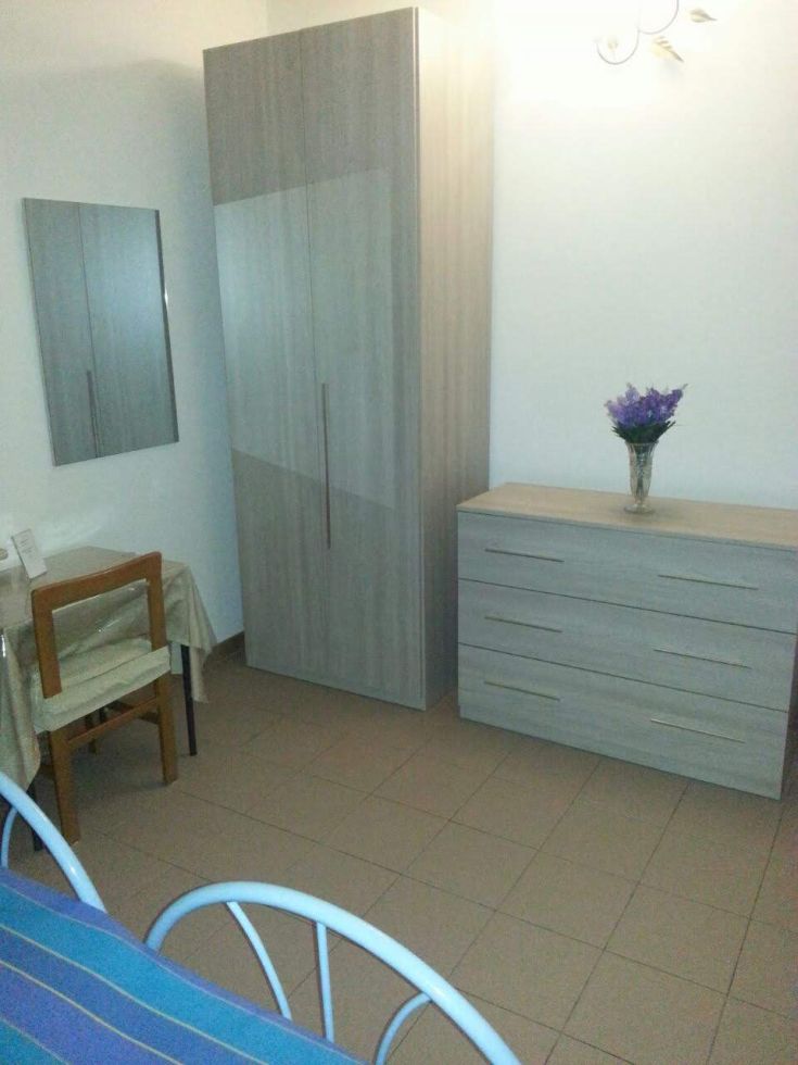 Chambre simple avec une armoire et des meubles en bois clair. Un environnement serein adapté au repos.