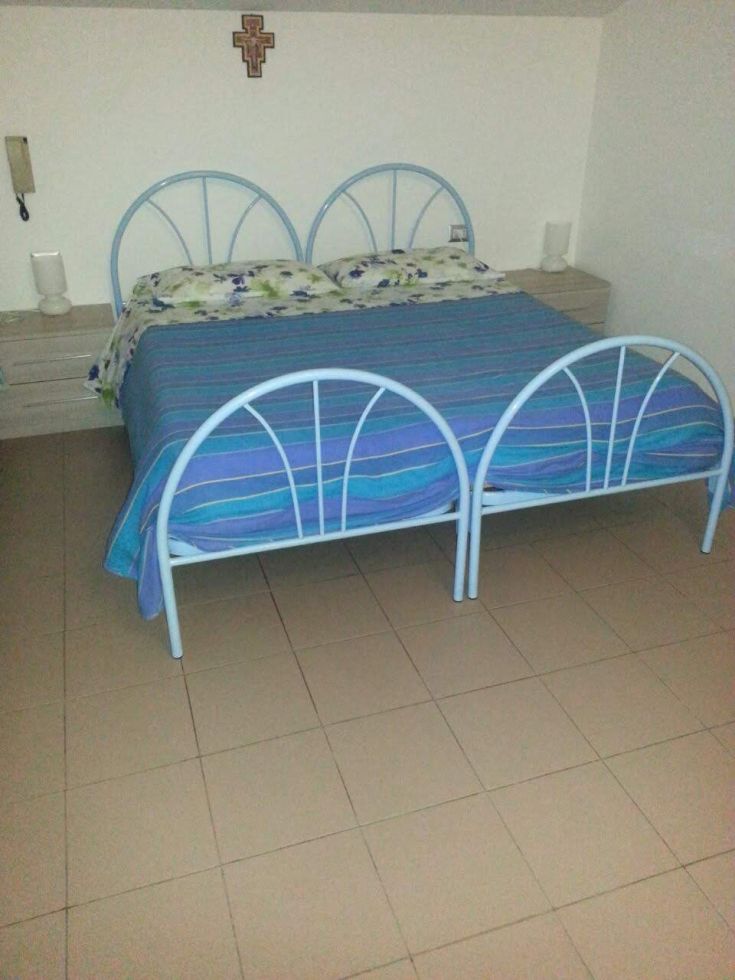 Chambre simple avec des lits bleus et des décorations florales, idéale pour un séjour relaxant.