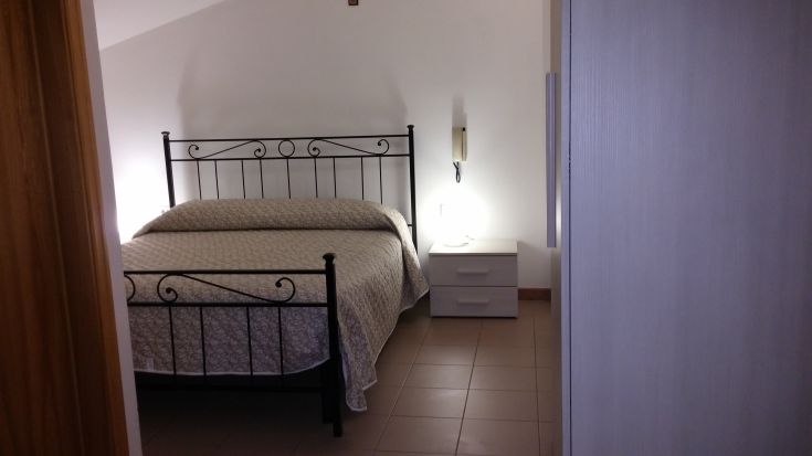 Chambre confortable avec un lit double et un mobilier essentiel, idéale pour des moments de détente.