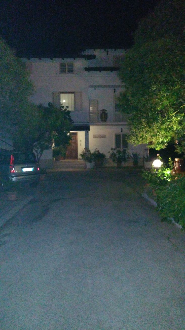 Complexe résidentiel éclairé, avec jardin et accès privé, plongé dans une atmosphère de soirée.