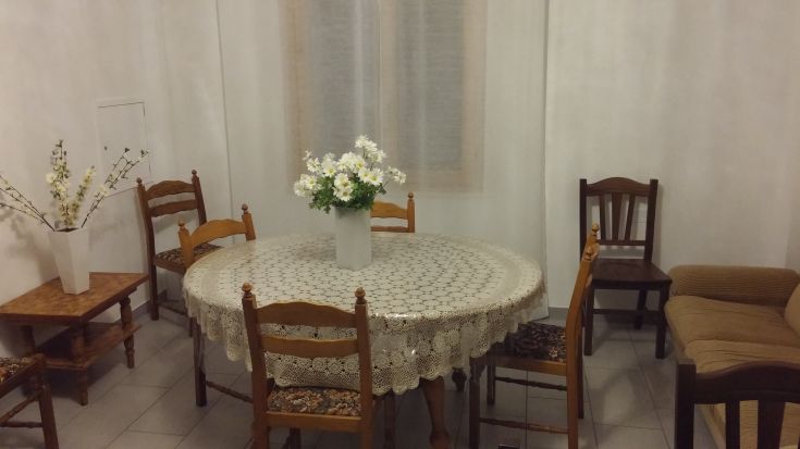 Une pièce accueillante avec une table ronde au centre, entourée de chaises et d'un canapé confortable pour se détendre.