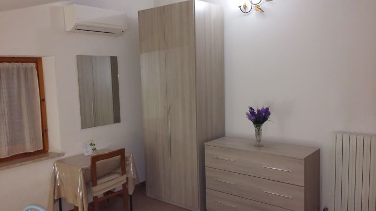 Chambre simple avec décoration moderne, coin bureau et vue sur un jardin. Espace idéal pour se détendre.