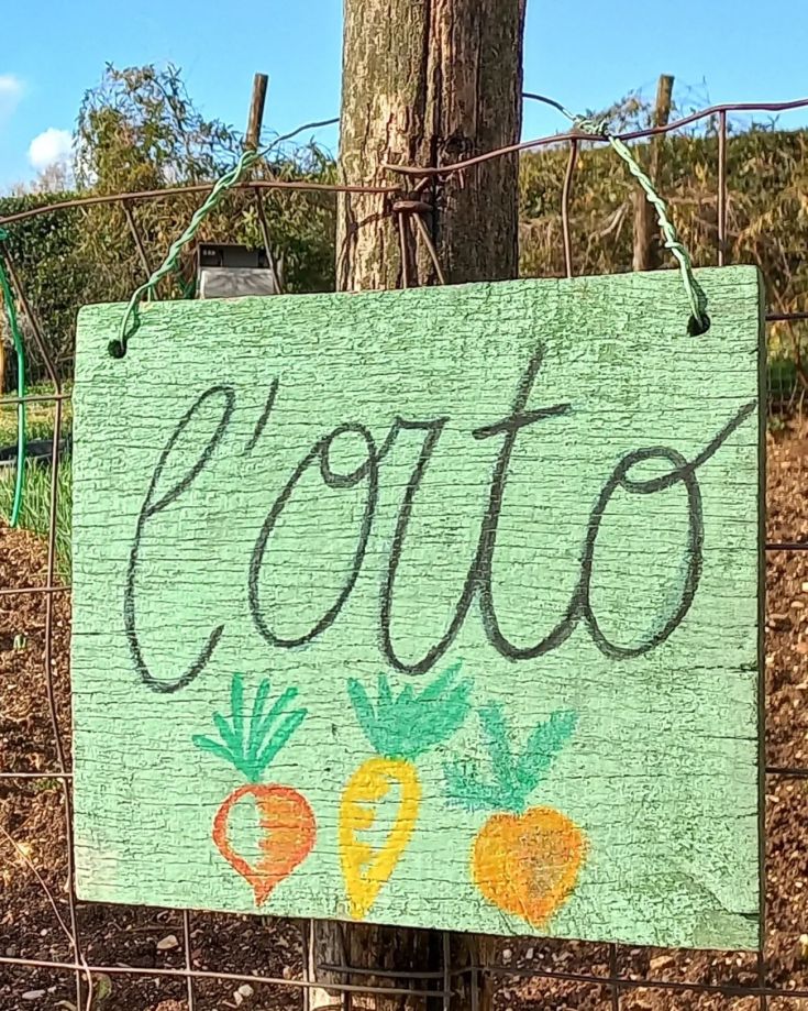 Un panneau en bois vert avec l'inscription 