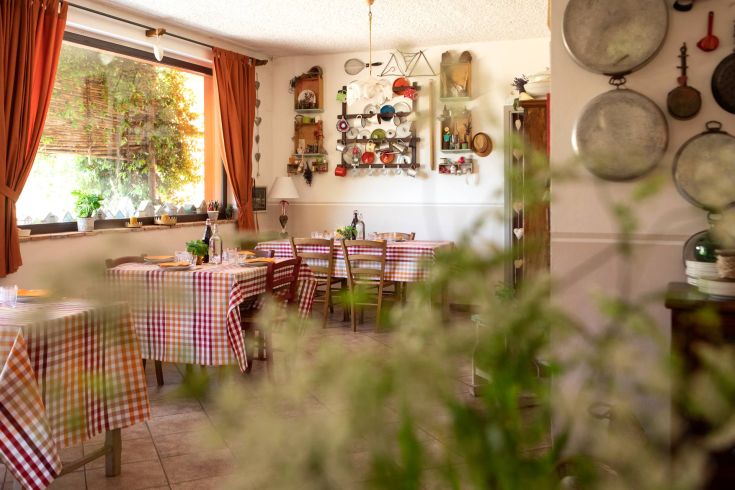 Un restaurant décontracté avec des tables carrées et une ambiance chaleureuse, décoré avec des embellissements simples.