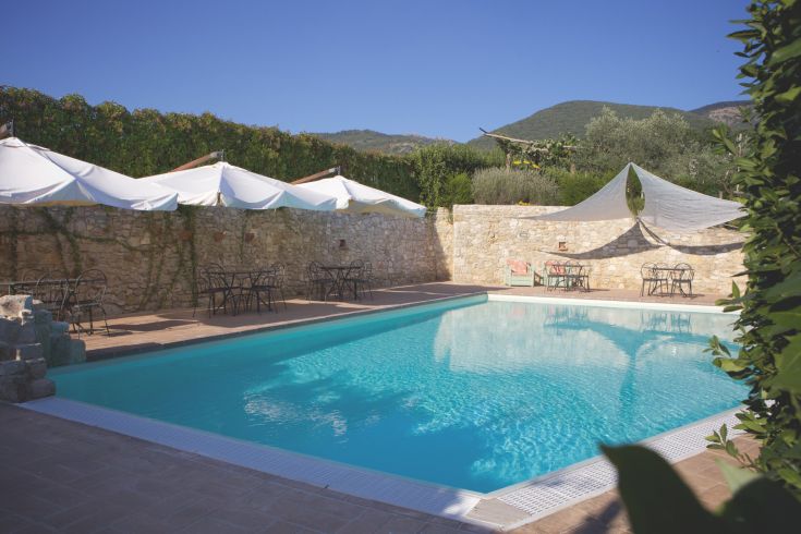 Une zone relaxante en Ombrie avec une piscine, entourée d'oliviers et dans une atmosphère familiale.