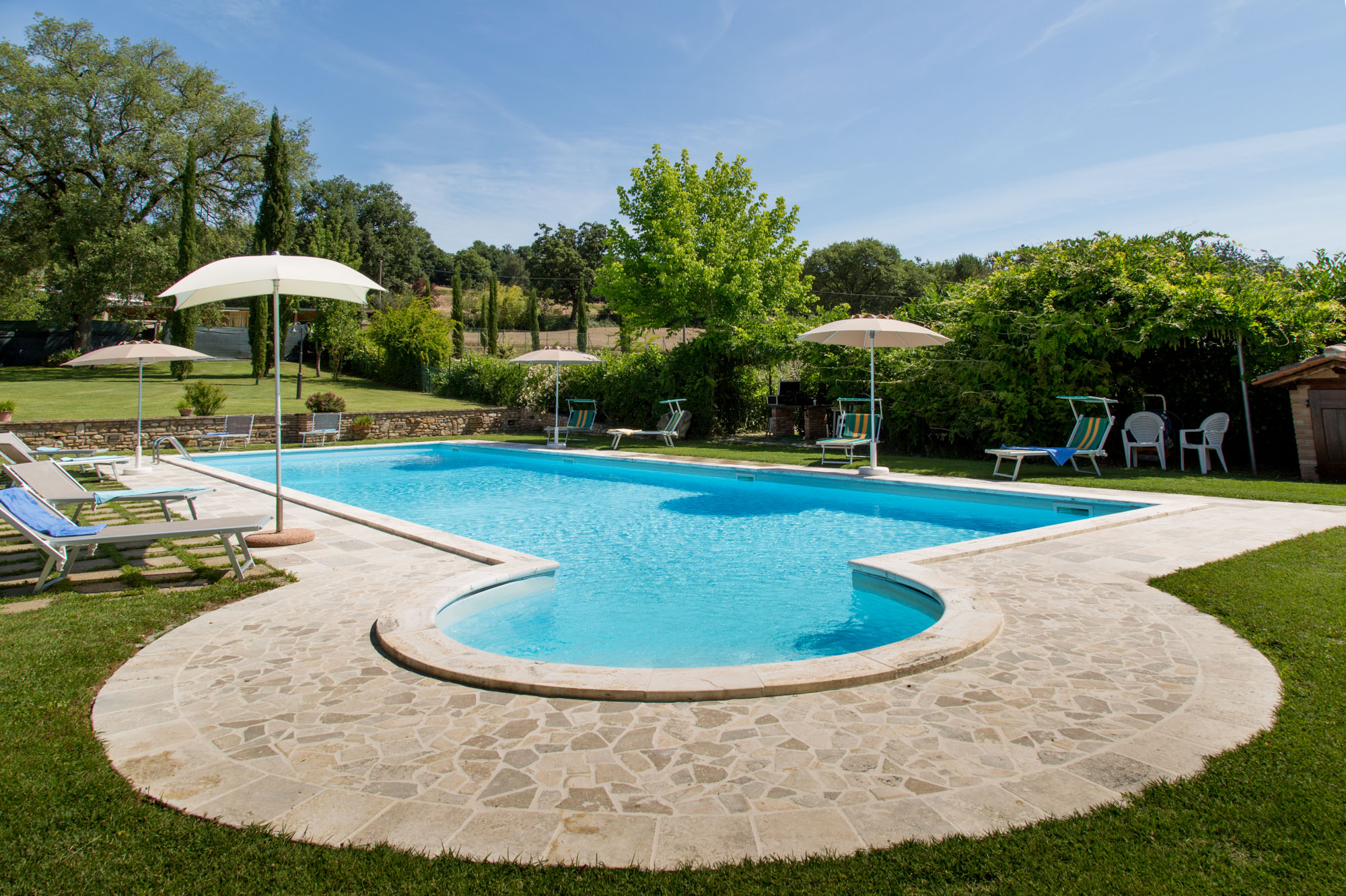 Una villa con piscina, immersa in un ampio giardino, adatta per famiglie e gruppi di amici.