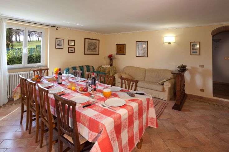 Gemütliche Atmosphäre mit einem schön gedeckten Esstisch und gut beleuchtetem Wohnzimmer, ideal für gemeinsame Momente.