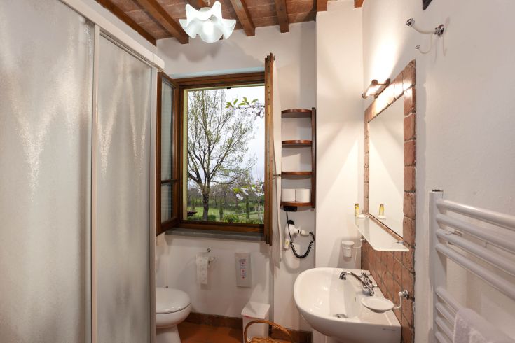 Ein modernes Badezimmer mit stilvollen Oberflächen, gut beleuchtet und mit Blick auf eine grüne Landschaft.