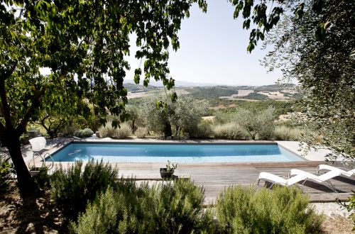 Moderne Pool mit zeitgenössischem Design, umgeben von üppigen grünen Hügeln in einer ruhigen Umgebung.