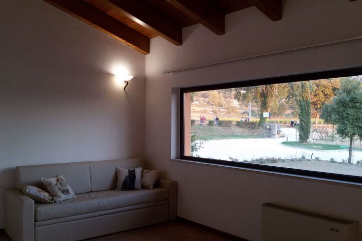 Innenraum eines Hauses mit großem Fenster, das einen Blick auf den Garten bietet.