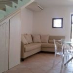 Ein komfortables Wohnzimmer mit Sofa und Tisch in einer hellen, geräumigen Umgebung.