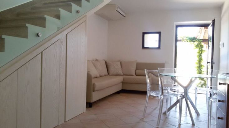 Ein gemütliches Wohnzimmer mit Sofa und Tisch, durch warmes, natürliches Licht erhellt.