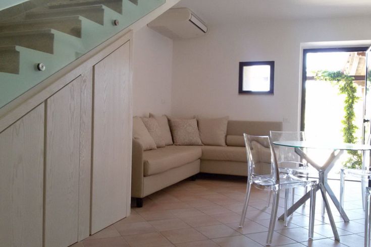 Modernes und helles Interieur mit Sofa und transparentem Glastisch.