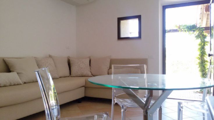 Ein helles Wohnzimmer mit einem gemütlichen Sofa und einem Glastisch, einladend und gut eingerichtet.