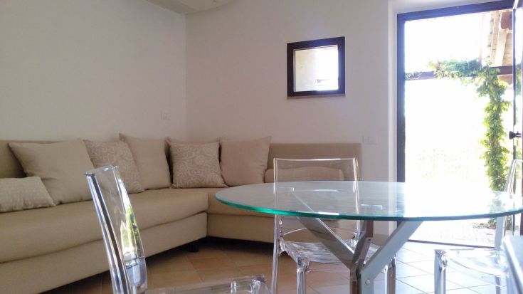 Helles und modernes Wohnzimmer mit einem gemütlichen Sofa und einem Glastisch für eine einladende Atmosphäre.