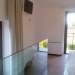 Helles Innendesign eines Landhauses mit großen Fenstern und minimalistischer Einrichtung.